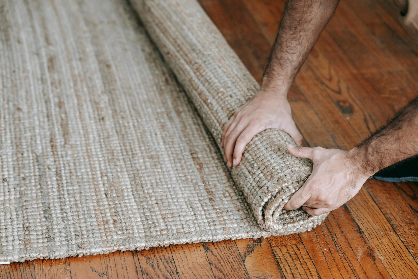 Person rolling up a rug